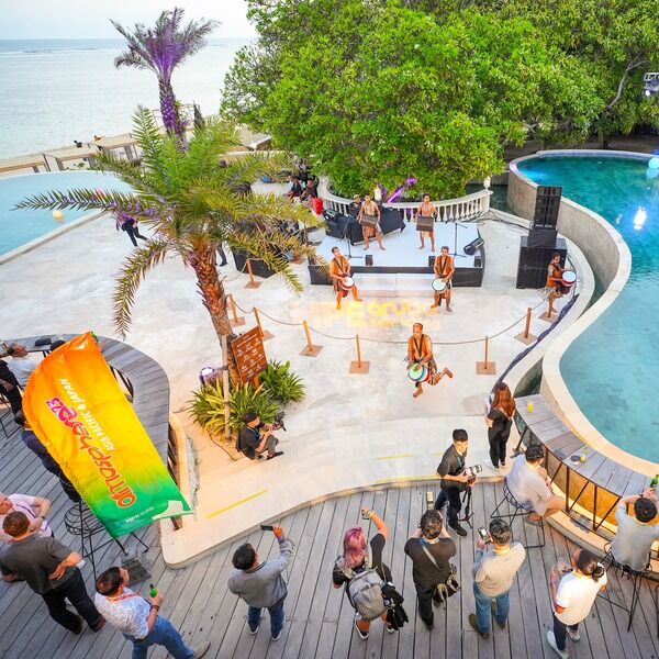 Atmosphere '23 attendees gather around a poolside and beach, enjoying the lively atmosphere and vibrant surroundings.